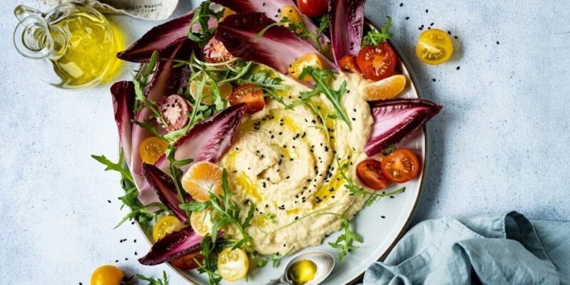 A healthy snack of humous, tomatoes and citrus fruit.