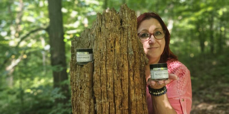 Silvia Patrocinio Roseiro of Enchanted Lotus Beauty Products holding up her first skin care product, her moisturiser.